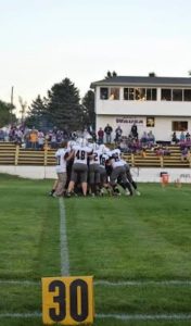 The Broncos huddle before the first district game against the Wausa Vikings